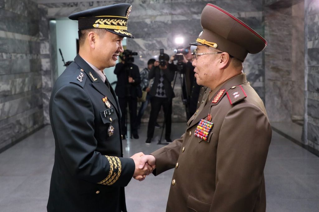 Ketua Delegasi Korea Selatan Mayor Jenderal Kim Do-gyun (kiri) berjabatan tangan dengan Ketua Delegasi Korea Utara Letnan Jenderal An Ik San (kanan) sebelum keduanya berunding di Desa Panmunjom di Zona Demiliterisasi, Korea, Jumat (26/10/2018).