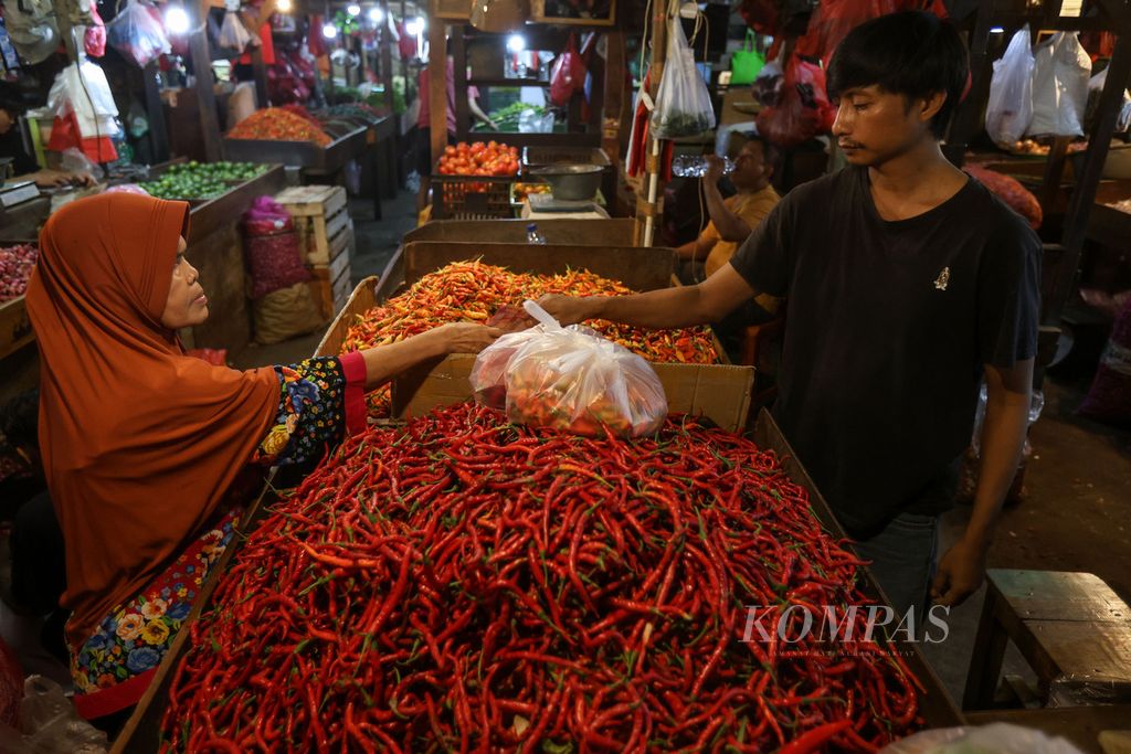Pembeli membayar pesanan cabai yang dipesannya di Pasar Senen, Jakarta Pusat, Selasa (26/12/2023).