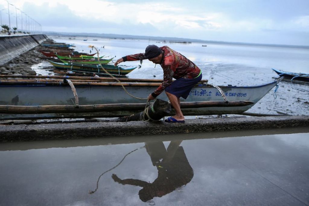 Seorang nelayan mengamankan perahunya di tepi pantai Sorsogon, Provinsi Sorsogon, Filipina, Jumat, 28 Oktober 2022, menjelang pendaratan badai tropis Nalgae atau Paeng dalam bahasa Tagalog. 
