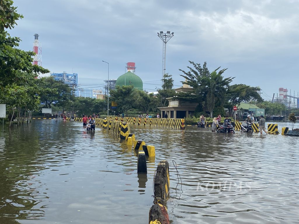 Para pekerja mendorong kendaraannya keluar dari kawasan Pelabuhan Tanjung Emas, Kota Semarang, Jawa Tengah, Rabu (26/5/2022). Ribuan kendaraan para pekerja di kawasan itu terendam banjir rob selama beberapa hari lantaran ditinggal pemiliknya menyelamatkan diri saat tanggul laut di kawasan itu jebol pada Senin (23/5/2022). Kendaraan-kendaraan itu langsung dibawa ke bengkel untuk diperbaiki setelah terendam banjir rob setinggi 1,5 meter.