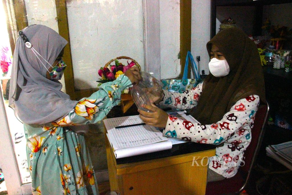 Salah satu siswa membawa botol plastik bekas saat bimbingan belajar di Kampung Literasi Selamat, Kota Pontianak, Kalimantan Barat, Kamis (17/3/2022). Sampah botol itu akan diolah menjadi berbagai hiasan.