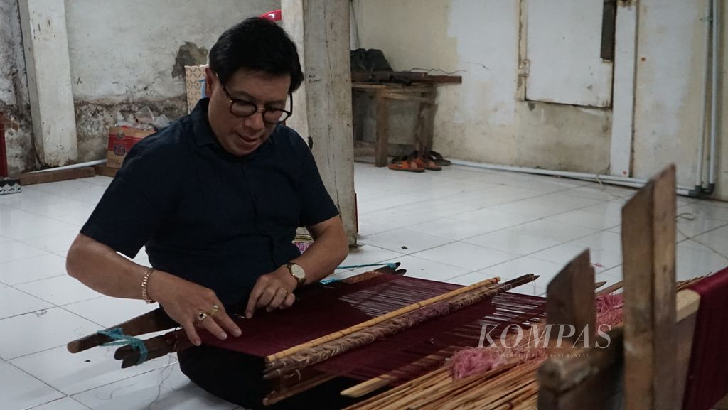 Perajin songket Palembang, Zainal Arifin (55), menenun songket di galerinya yang terletak di Jalan Ki Gede Ing Suro, Lorong Kuala Batu, 32 Ilir, Ilir Barat II, Palembang, Sumatera Selatan, Jumat (18/2/2022). Songket merupakan hasil budaya yang sudah ada sejak turun-temurun dan menjadi ciri khas Kota Palembang.