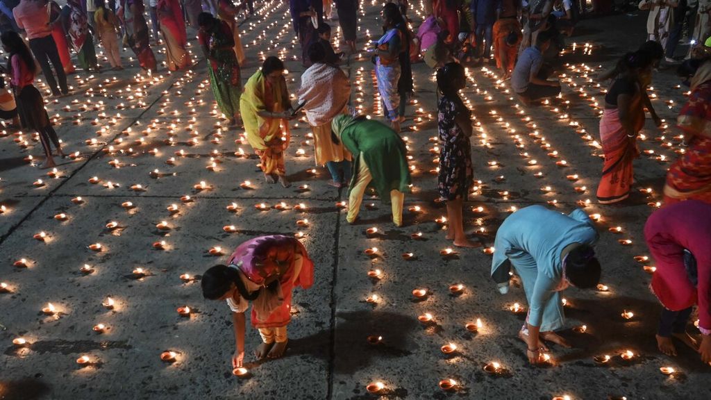 Umat Hindu menyalakan lampu minyak tradisional untuk merayakan festival Diwali di tepi sungai suci Gangga, Kolkata, India, Senin (30/11/2020) malam. Festival Diwali adalah tradisi perayaan cahaya bagi pemeluk Hindu yang merupakan simbol kemenangan kebaikan atas keburukan.