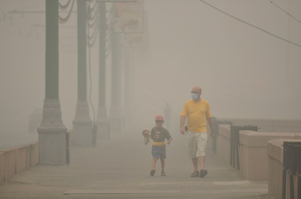 Warga memakai masker penutup hidung saat berjalan di Moskwa, Rusia, yang telah seminggu terakhir dikepung kabut asap akibat kebakaran hutan dan lahan. Foto diambil pada hari Sabtu (7/8/2010) sore. 