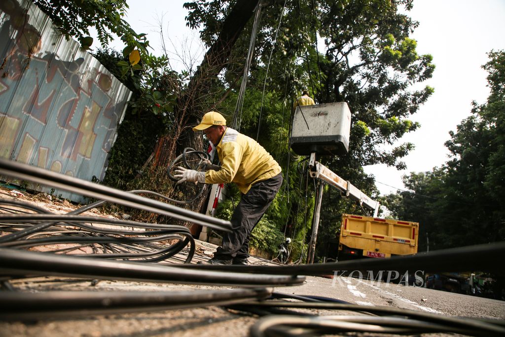 Petugas dari Dinas Bina Marga DKI Jakarta mengumpulkan kabel fiber optik yang ditertibkan di Menteng, Jakarta Pusat, Jumat (11/8/2023). 