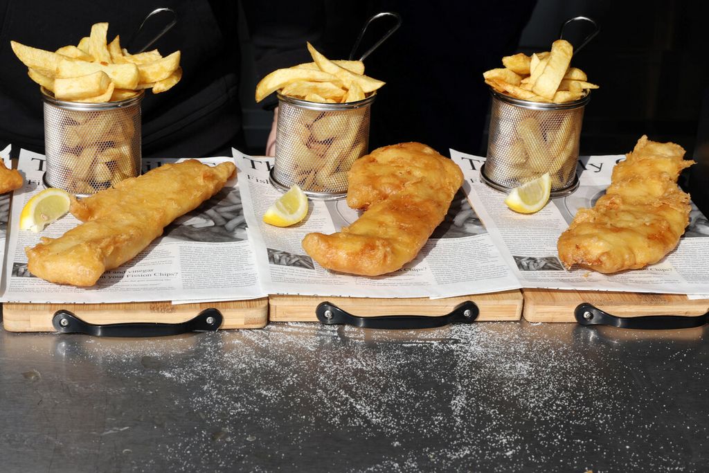 Makanan ringan ikan dan kentang goreng sebelum disajikan saat jam makan siang di kedai Captain's Fish and Chip di Brighton, Inggris, Jumat (25/3/2022). Inflasi membuat harga makanan itu melonjak.
