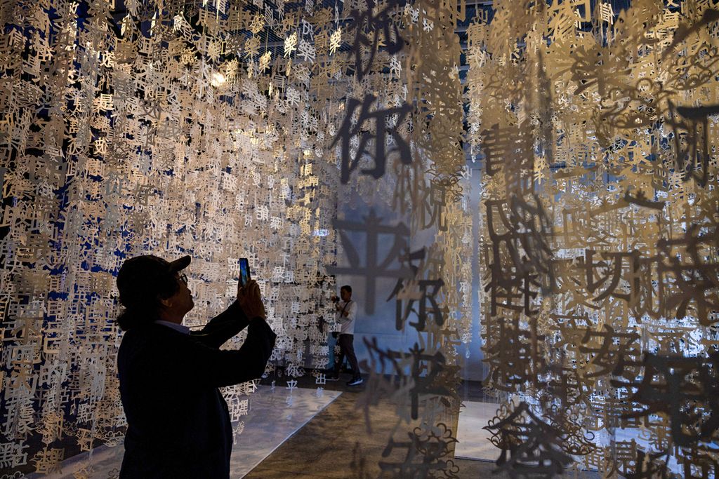 Foto yang direkam pada 12 Oktober 2023 ini menunjukkan seorang pria memotret karya instalasi seni "Menerima Kebahagiaan" buatan Chen Zhi-Xu dan Raito Low. Karya itu dipamerkan di Shanlong Performance Hall, bekas gedung pertunjukan militer Taiwan yang kini berubah menjadi obyek wisata. Aula itu salah satu lokasi Matsu Biennial 2023.