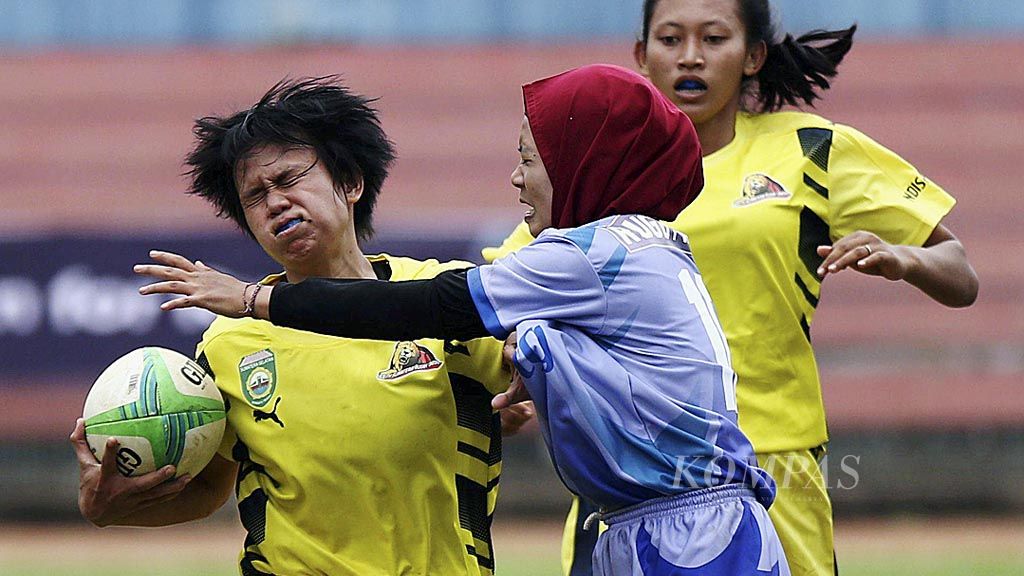 Pemain tim rugbi putri Sumatera Selatan, Mery (kiri), berusaha mempertahankan bola dari pemain tim rugbi Jawa Tengah dalam Kejuaraan Nasional Rugbi  di Stadion Kuningan, Jakarta, Rabu (25/10). Kejurnas ini sekaligus menjadi uji coba kejuaraan untuk Asian Games Jakarta-Palembang 2018.