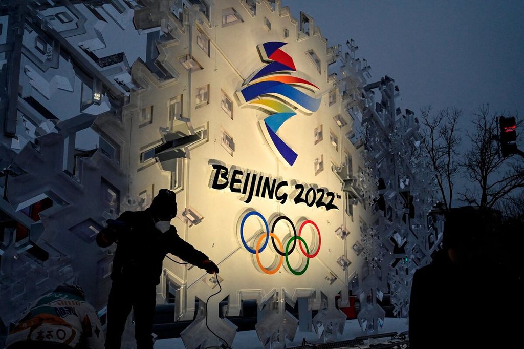 Pekerja memasang instalasi logo Olimpiade Musim Dingin Beijing 2022 di sepanjang jalan di Beijing, China, Jumat (21/1/2022). 