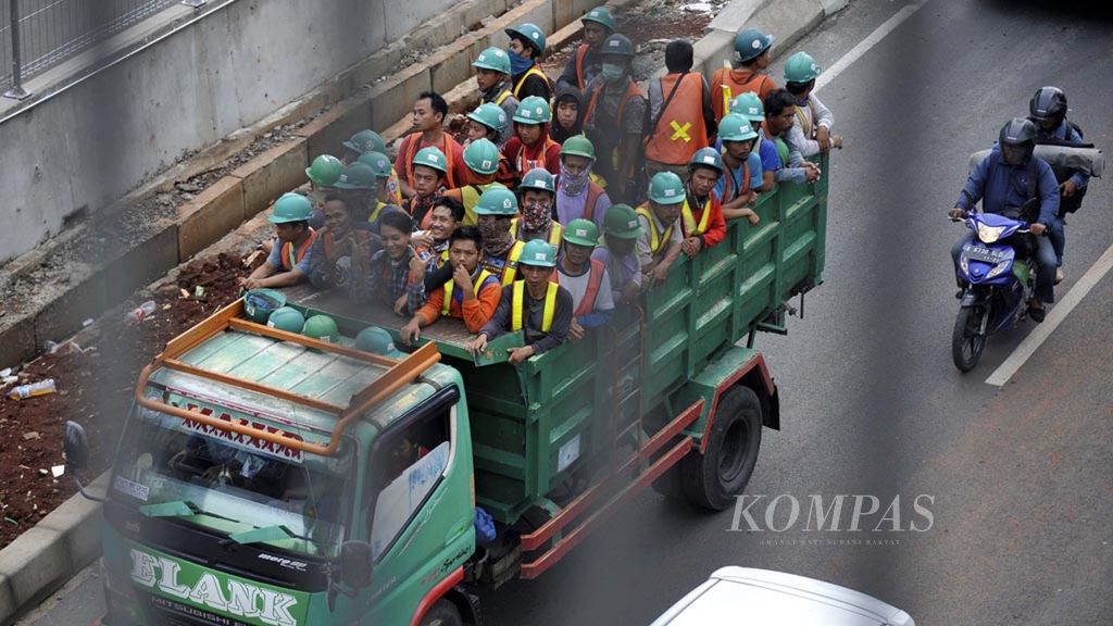 Para pekerja proyek infrastruktur naik di atas truk saat menuju lokasi kerja di Jalan TB Simatupang, Cilandak, Jakarta Selatan, Selasa (23/10/2018). Proyek infrastruktur yang dibangun pemerintah saat ini mampu menyerap lebih dari 200.000 pekerja.