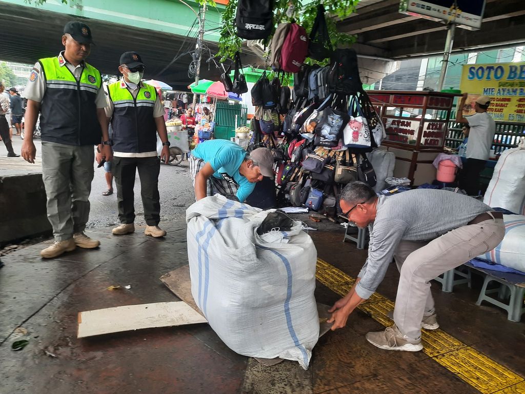 Sejumlah pedagang meminggirkan barang-barangnya setelah Satuan Polisi Pamong Praja (Satpol PP) menertibkan di sepanjang Jl H Fachrudin, Tanah Abang, Jakarta, Rabu (15/3/2023). 
