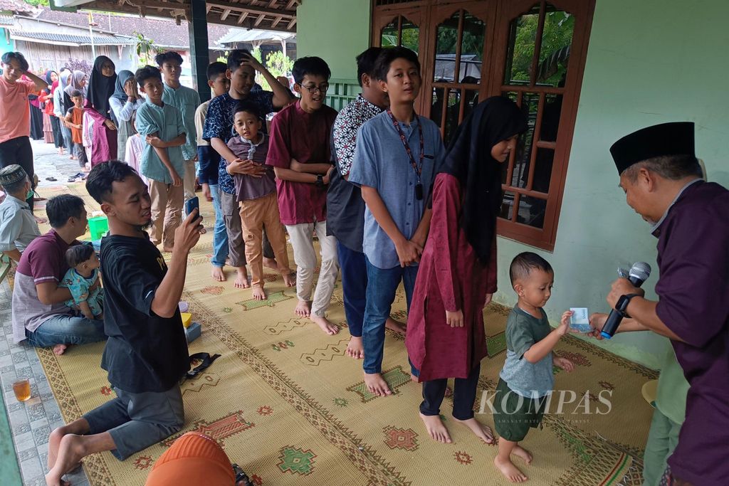 Bagi-bagi rezeki atau THR menjadi hal yang dinantikan anak-anak saat kumpul keluarga besar atau trah saat momen Hari Rara Idul Fitri seperti yang dilakukan trah Bani Syahidi di Desa Ponjong, Kecamatan Ponjong, Gunung Kidul, DI Yogyakarta, Minggu (23/4/2023). 