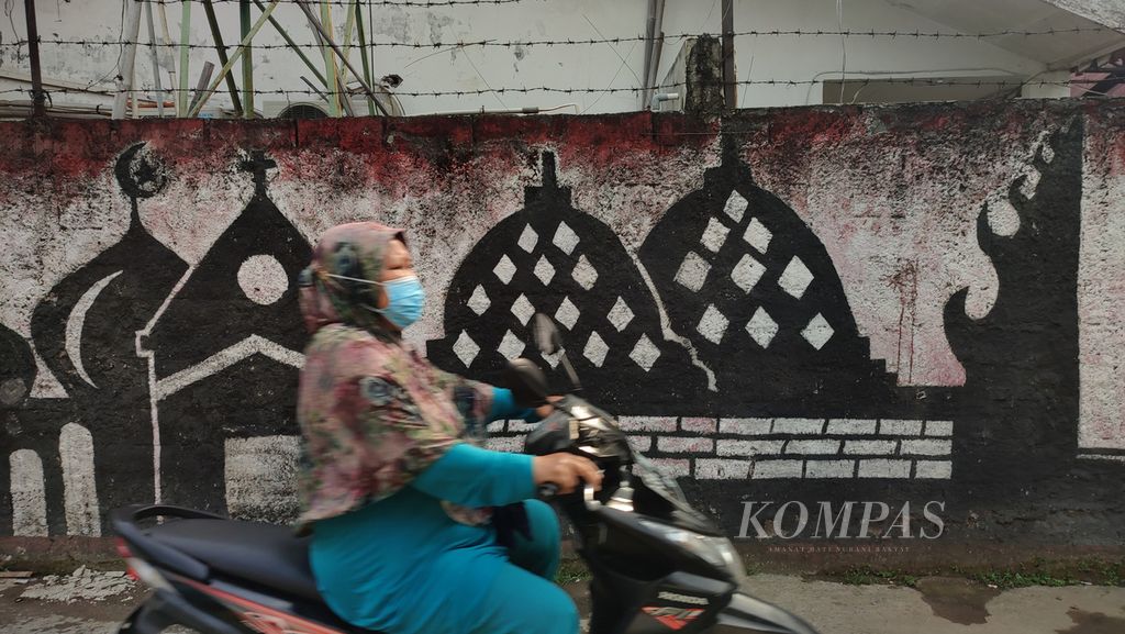 Mural bertema toleransi beragama digambar di sebuah gang di kawasan Pondok Labu, Jakarta, Rabu (6/7/2022). Di tengah masyarakat Indonesia yang majemuk, praktik moderasi beragama harus terus dikedepankan dan menjadi kebutuhan nyata bangsa yang agamis. 