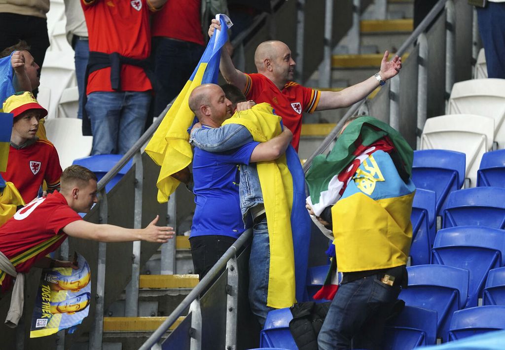 Fans timnas Wales dan fans timnas Ukraina saling mengucapkan selamat seusai pertandingan final playoff kualifikasi Piala Dunia 2022 antara Ukraina dan Wales di Stadion Cardiff City, Cardiff, Minggu (5/6/2022). Ukraina gagal ke putaran final Piala Dunia 2022 setelah dikalahkan Wales, 0-1. 