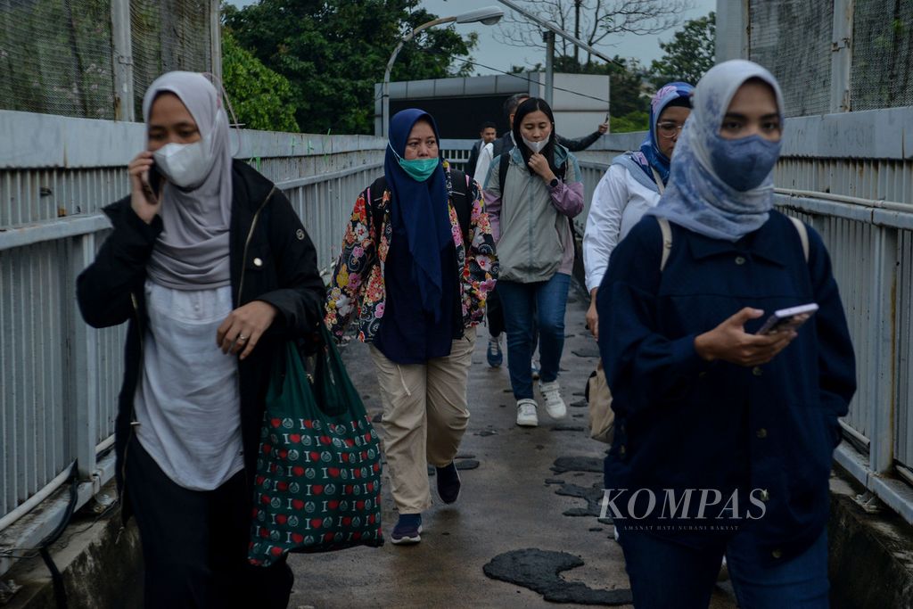 Para pekerja berjalan di jembatan penyeberangan di Jalan Gatot Subroto, Jakarta, saat jam pulang kerja pada Senin (19/6/2023).