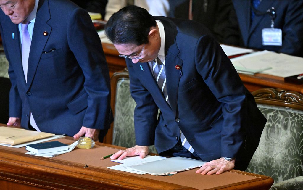Perdana Menteri Jepang Fumio Kishida (kanan) membungkuk setelah mosi tidak percaya terhadap kabinetnya, yang diajukan partai oposisi atas skandal pendanaan partai besar, ditolak dalam sidang paripurna parlemen di Tokyo, Jepang, Rabu (13/12/2023). 