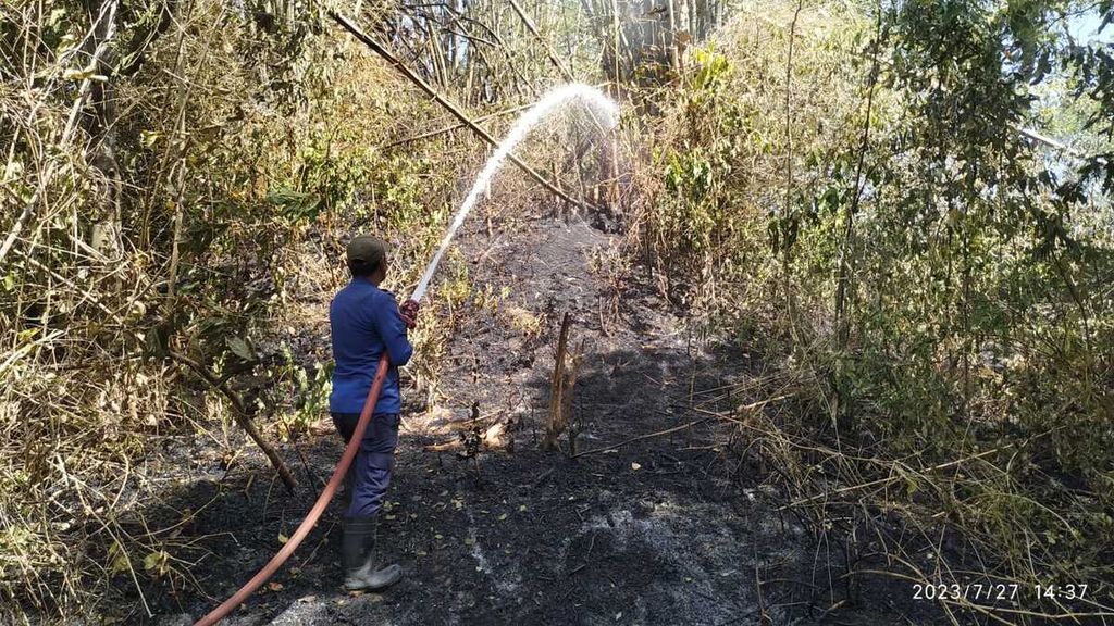 Petugas memadamkan api yang membakar lahan di Kabupaten Aceh Besar, Provinsi Aceh, Kamis (27/7/2023).