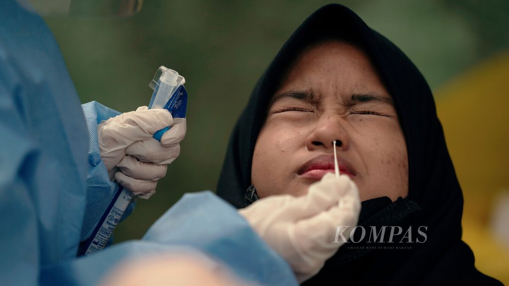 Pelajar SMKN 35 menjalani tes usap di RW 002 Kelurahan Krukut, Kecamatan Taman Sari, Jakarta Barat, Selasa (11/1/2022). Penguncian lokal, penyemprotan disinfektan, serta pelacakan tes antigen dan PCR dilakukan di kawasan padat penduduk tersebut.