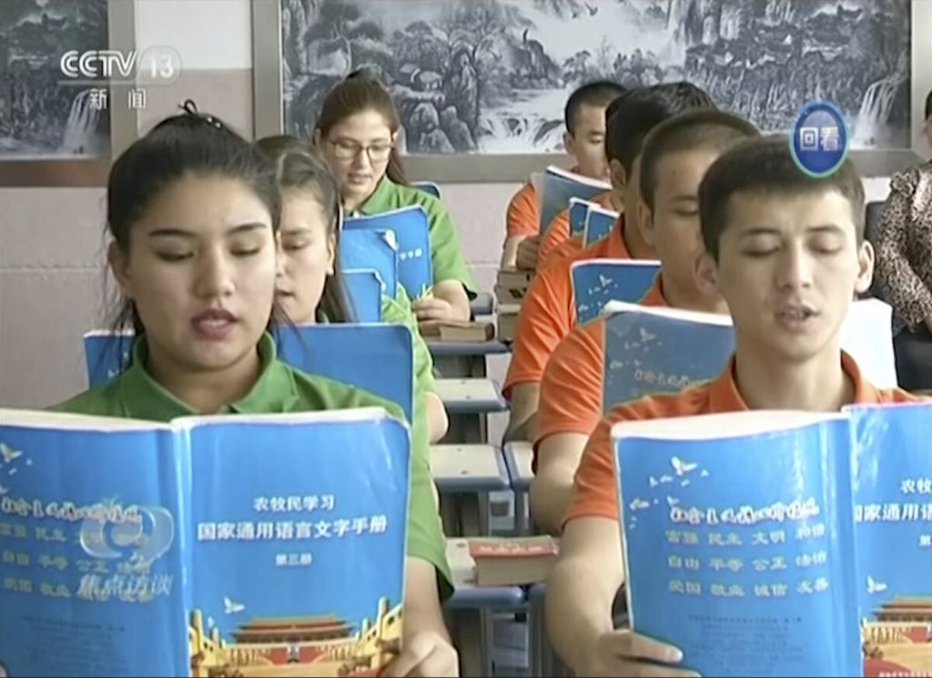Tangkapan layar dari video oleh stasiun televisi nasional China, CCTV, menunjukkan anak-anak kelompok etnis minoritas Uyghur di Provinsi Otonom Xinjiang sedang membaca buku pelajaran berbahasa Mandarin. Rekaman diambil di Pusat Pendidikan dan Pelatihan Vokasi Hotan.    