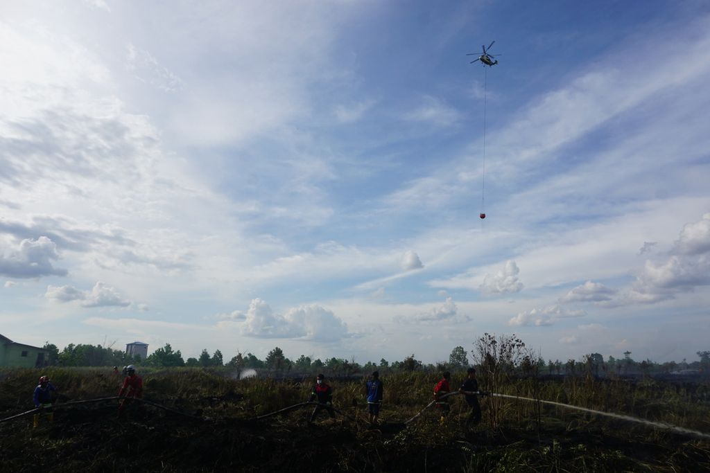 Ilustrasi. Petugas pemadam kebakaran dan Manggala Agni Kota Palangkaraya memadamkan api yang membakar lahan gambut tipis seluas 2 hektar di Jalan Danau Rangas, Kota Palangkaraya, Kalimantan Tengah, Selasa (6/10/2020). Tak hanya itu, helikopter bom air milik BNPB pun ikut membantu pemadaman api.