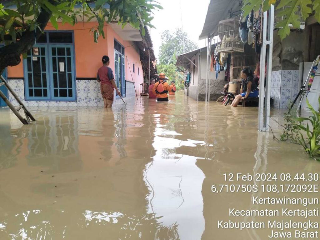 Petugas Badan Penanggulangan Bencana Daerah Kabupaten Majalengka mengecek kondisi banjir di Kecamatan Kertajati, Kabupaten Majalengka, Jawa Barat, Senin (12/2/2024). Banjir merendam 1.300 rumah, termasuk jalur keluar Tol Kertajati.