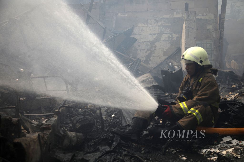 Petugas pemadam kebakaran memadamkan api yang membakar bangunan permanen dan semipermanen di kawasan padat hunian Jalan Simprug Golf, Kebayoran Lama, Jakarta Selatan, Minggu (21/8/2022). 