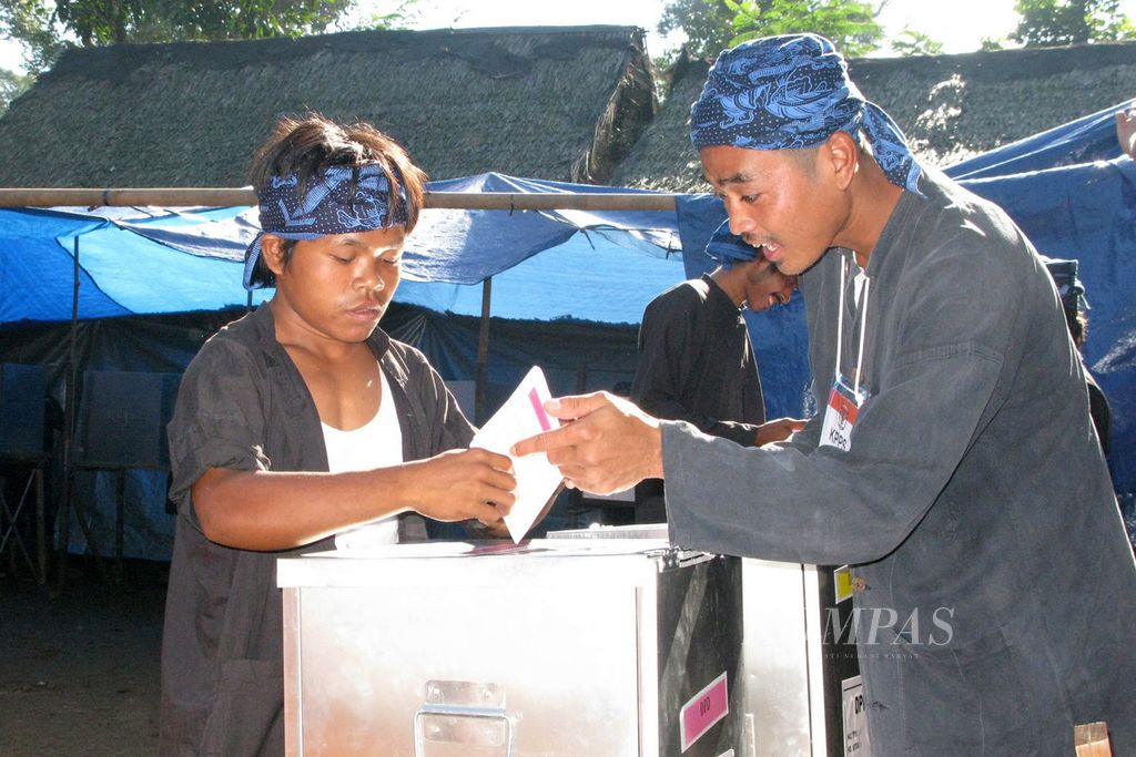 Seorang warga Baduy Luar dibantu petugas memasukkan surat suara ke kotak di TPS khusus di Kampung Kadu Ketug, Desa Kanekes, Kecamatan Leuwidamar, Kabupaten Lebak, Banten, Kamis (9/4/2009). 