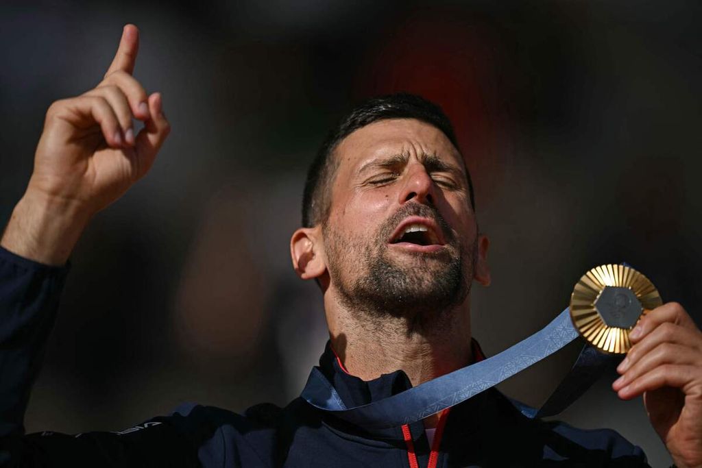 Petenis Serbia, Novak Djokovic, berpose dengan medali emas tenis tunggal putra Olimpiade Paris 2024 seusai mengalahkan petenis Spanyol, Carlos Alcaraz, di Roland Garros, Paris, Minggu (4/8/2024).