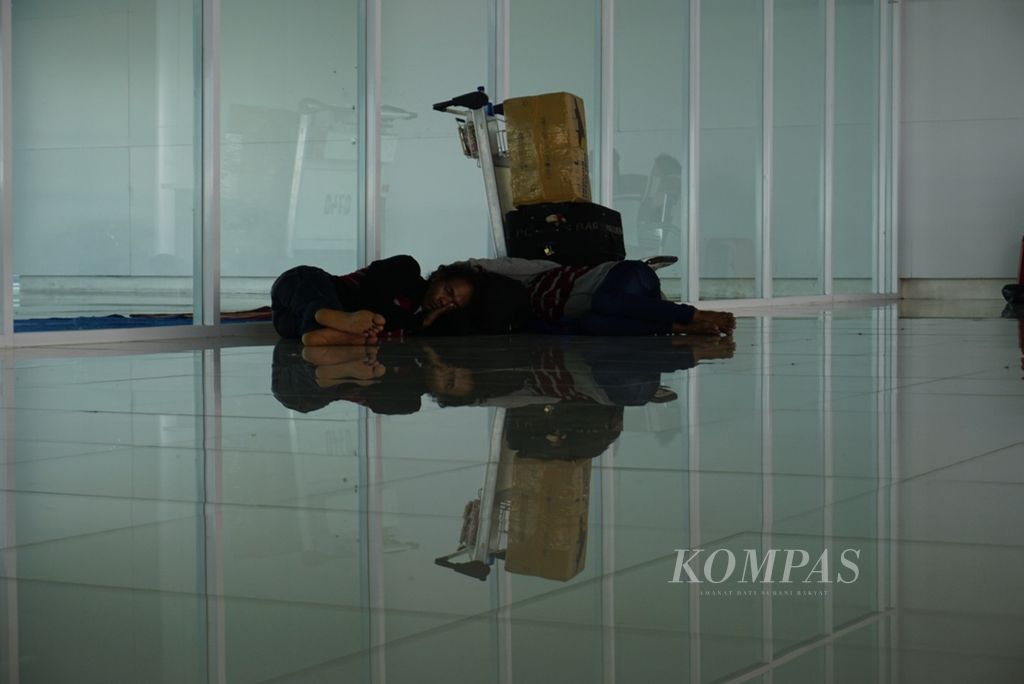 Dua penumpang tidur di Bandara Sultan Aji Muhammad Sulaiman Sepinggan Balikpapan, Kalimantan Timur, Rabu (18/9/2019). Mereka beristirahat sambil menunggu pesawat yang datang.