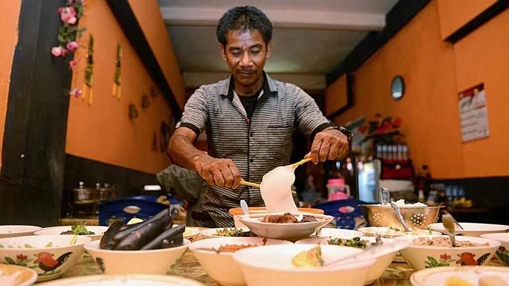 Warga bersiap menyantap makanan Papeda di kawasan Pasar Gamalama, Ternate, Maluku Utara, Senin (11/3/2019).