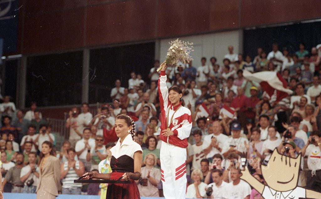 Pemain bulu tangkis putri terbaik, Susi Susanti mengangkat bunga setelah menerima pengalungan medali emas tunggal putri bulu tangkis Olimpiade 1992 yang diraihnya di Pavelo de la Marbella, Barcelona, Selasa (4/8/1992). Susi menjadi orang Indonesia pertama yang mempersembahkan medali emas olimpiade bagi Ibu Pertiwi. Susi memastikan keberhasilannya setelah menundukkan pemain Korea Selatan Bang Soo-hyun di final.