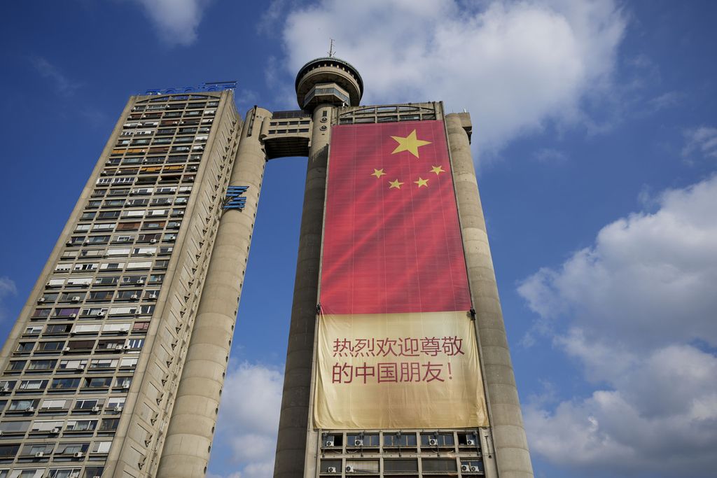 Pekerja memasang bendera China di gedung pencakar langit di Beograd, Serbia, Sabtu (4/5/2024), menjelang kunjungan Presiden China Xi Jinping.