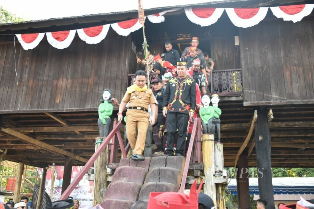 Gubernur Kalteng Sugianto Sabran dan Bupati Gunung Mas Jaya S Monong menuruni rumah panjang Tumbang Anoi, Kabupaten Gunung Mas, Kalteng, Selasa (23/7/2019).