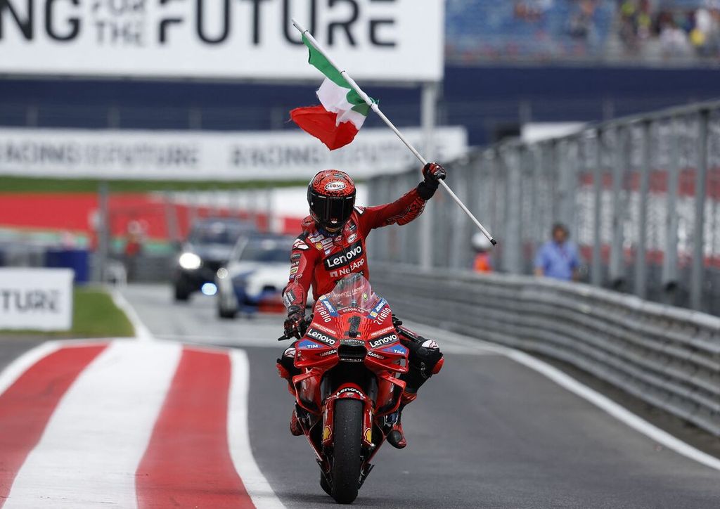 Pebalap Ducati Lenovo, Francesco Bagnaia, membawa bendera Italia sebagai perayaan kemenangan pada balapan MotoGP seri Austria di Sirkuit Red Bull Ring di Spielberg, Austria, Minggu (18/8/2024). 