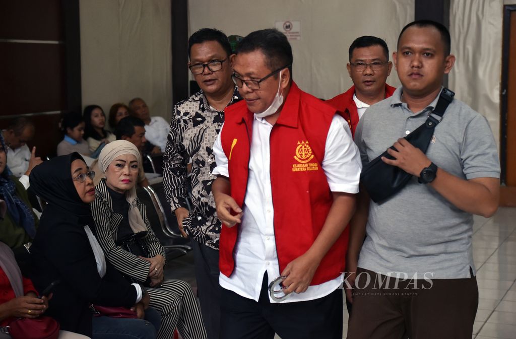 Mantan Sekretaris Umum Komite Olahraga Nasional Indonesia (KONI) Sumatera Selatan Suparman Romans (tengah) dan mantan Ketua Harian KONI Sumsel Ahmat Tahir (kanan kedua) digiring ke ruang sidang di Pengadilan Tindak Pidana Korupsi Palembang, Sumsel, Senin (11/12/2023). 