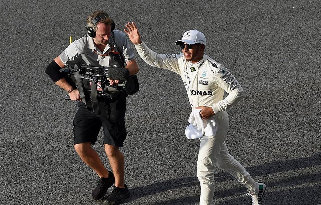 Pebalap Mercedes, Lewis Hamilton, melambaikan tangan ke tribune penonton setelah memastikan merebut posisi start terdepan (pole position) pada sesi kualifikasi Formula 1 GP Malaysia di Sirkuit Sepang, Sabtu (30/9).