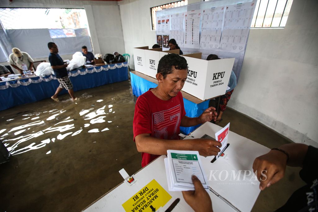 Suasana penyaluran suara Pemilu 2024 di TPS 20 di Kelurahan Larangan Utara, Larangan, Kota Tangerang, Banten, yang terendam banjir, Rabu (14/2/2024). Meskipun dikepung banjir, antusiasme masyarakat setempat cukup tinggi untuk mendatangi TPS guna menyalurkan suaranya.  