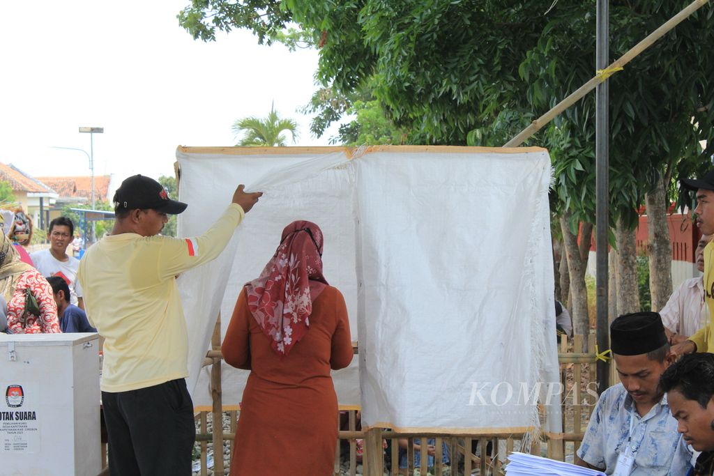 Warga memasuki bilik tempat pemungutan suara pemilihan kuwu atau kepala desa di Desa Kapetakan, Kecamatan Kapetakan, Kabupaten Cirebon, Jawa Barat, Minggu (22/10/2023). 