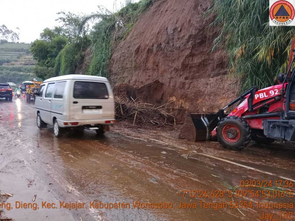 Kendaraan melintasi jalan yang baru dibersihkan dari material longsor di jalur Wonosobo-Dieng, Kecamatan Kejajar, Kabupaten Wonosobo, Jawa Tengah, Minggu (3/3/2024) sore.