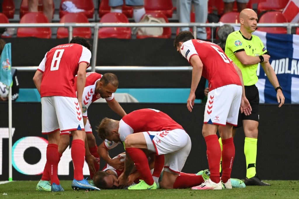 Pemain timnas Denmark memberi pertolongan pertama kepada gelandang Christian Eriksen yang kolaps di lapangan saat pertandingan Grup B Piala Eropa 2020 antara Denmark dan Finlandia di Stadion Parken, Kopenhagen, 12 Juni 2021.
