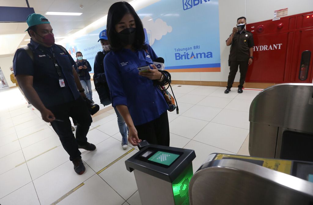Rombongan jurnalis menempelkan kartu JakLingko pada mesin pemindai pada pintu otomatis saat uji coba penggunaan kartu tersebut di Stasiun MRT Bundaran HI, Jakarta Pusat, Senin (4/10/2021).
