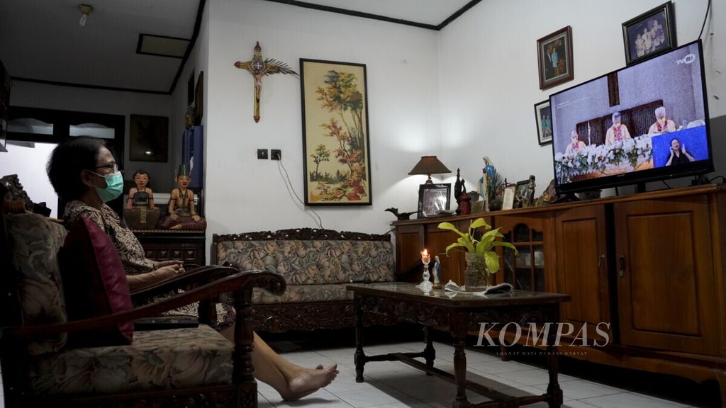 Ilustrasi. Ibu Yola (67) mengikuti misa malam Natal Gereja Santo Yakobus, Kelapa Gading, Jakarta, yang disiarkan secara langsung oleh TVRI dari rumahnya di kawasan Cipadu, Tangerang, Banten, Kamis (24/12/2020).