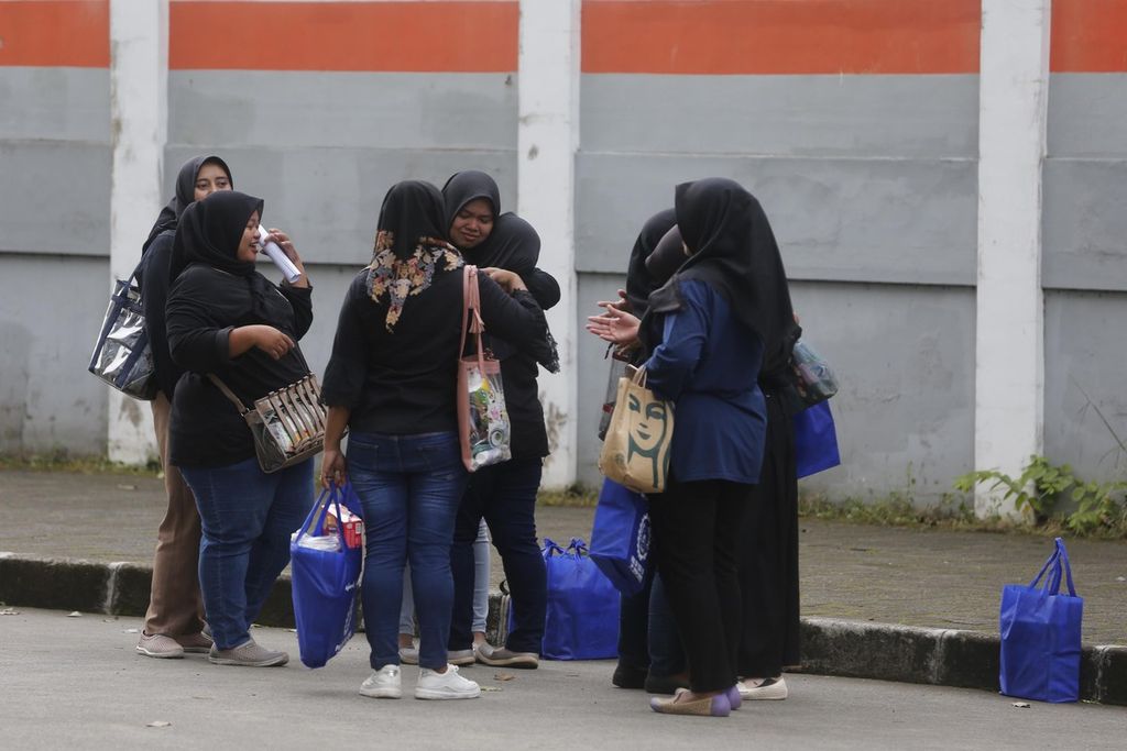 Karyawan pabrik sepatu PT Dean Shoes Karawang, Jawa Barat, saling berpelukan setelah mendapat surat pemutusan hubungan kerja (PHK), Selasa (28/3/2023). PT Dean Shoes menutup pabrik dan menghentikan operasi pada 14 April. Sebanyak 3.329 pekerja mengalami PHK.