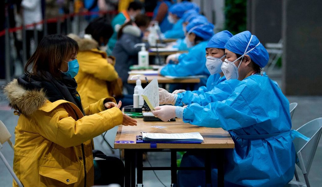 Petugas medis mendata warga yang akan menerima vaksin Covid-19 di Museum Perencanaan Kota Chaoyang di Beijing, China. Komisi Kesehatan Nasional pada hari Jumat mengatakan, terdapat 1.001 pasien dirawat karena Covid-19, sejumlah 26 di antaranya dalam kondisi serius. 
