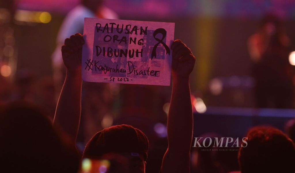 Penonton membawa poster bertuliskan duka atas tragedi Kanjuruhan dalam ajang Synchronize Festival 2022 di Gambir Expo, Kemayoran, Jakarta, Jumat (7/10/2022). 