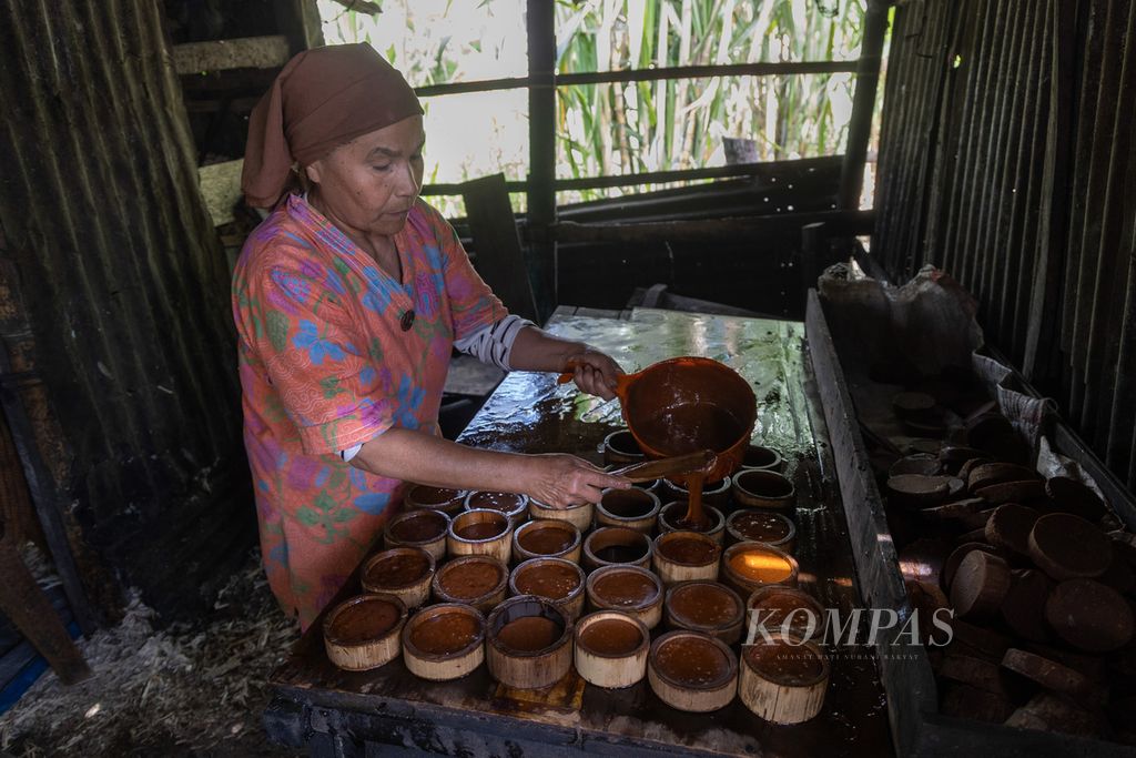 Erlinda (56) mencetak gula merah dari air tetes tebu di sebuah kilang tebu di Jorong Katapiang, Nagari Lawang, Kecamatan Matur, Kabupaten Agam, Sumatera Barat, Rabu (15/6/2023). 