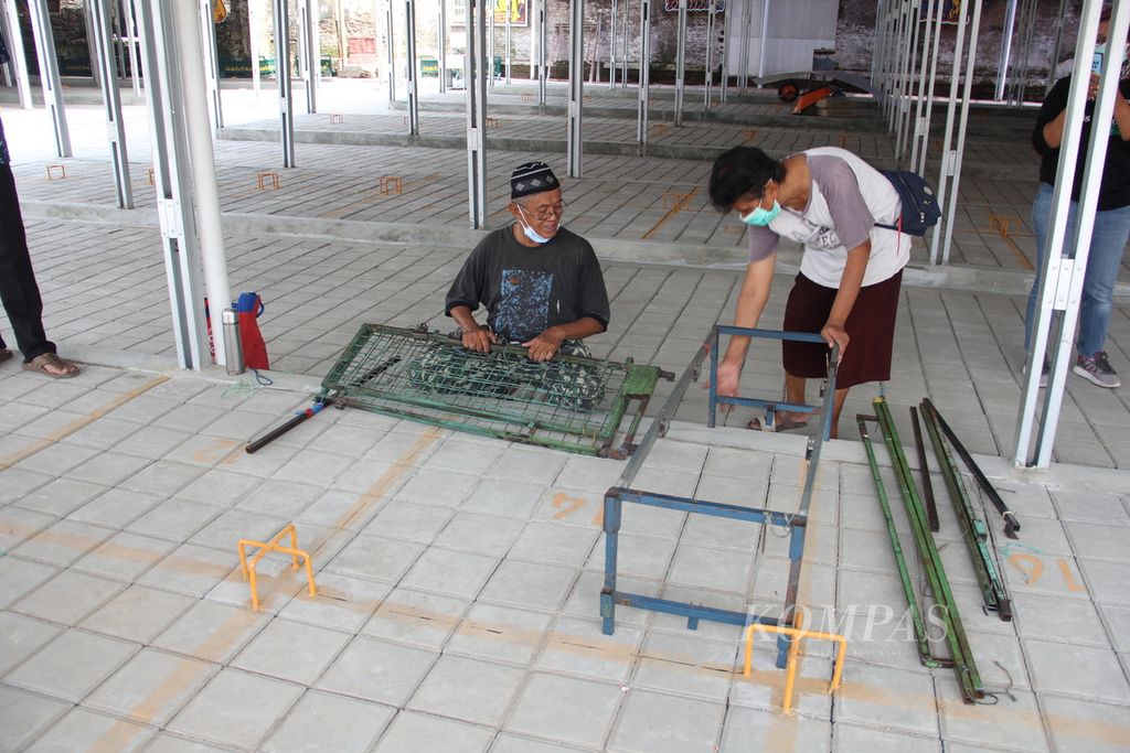 Sejumlah pedagang kaki lima menyiapkan rak untuk berjualan di tempat relokasi yang diberi nama Teras Malioboro II di kawasan wisata Malioboro, Kota Yogyakarta, Selasa (1/2/2022). 