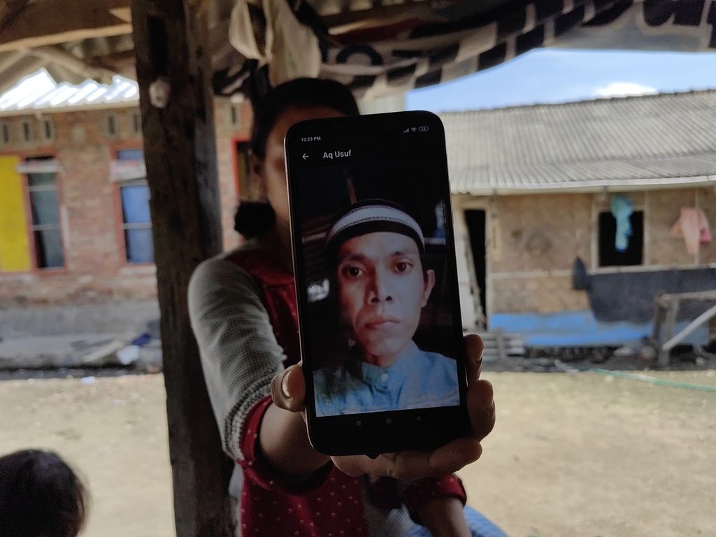 Jumisah menunjukkan foto suaminya di Dusun Mengiluk, Desa Batujai, Kecamatan Praya Barat, Lombok Tengah, Nusa Tenggara Barat, Jumat (17/6/2022), tidak kuasa menahan tangis. Dari dusun itu, ada lima warga yang turut dalam kecelakaan kapal pengangkut pekerja migran tanpa dokumen di perairan Batam pada Kamis (16/6/2022). Suami Jumisah yakni Muhammad Rahim masih hilang.