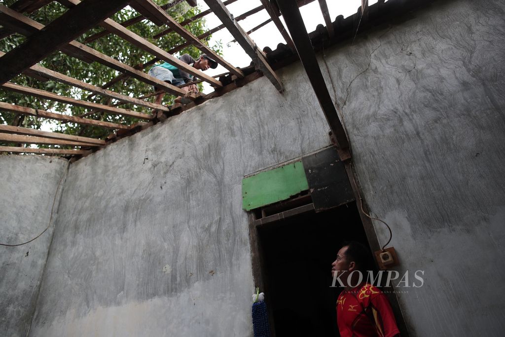 Warga Desa Taman Jaya, Sumur, Pandeglang, Banten, pertengahan Januari 2022 lalu, membetulkan kembali genteng rumahnya yang melorot dan jatuh akibat diguncang gempa pada 14 Januari 2022. 