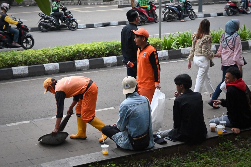 Petugas penanganan prasarana dan sarana umum membersihkan sampah warga di daerah Dukuh Atas, Kecamatan Tanah Abang, Jakarta Pusat, Senin (25/7/2022) sore. 